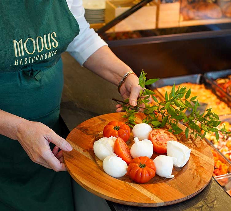Addetta della gastronomia Modus con un tagliere di mozzarelle