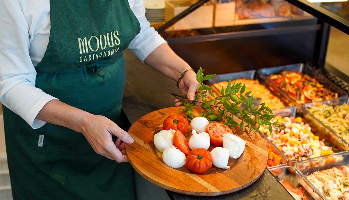 Addetta della gastronomia Modus con un tagliere di mozzarelle