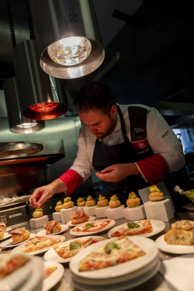Chef che impiatta antipasti al banco della cucina