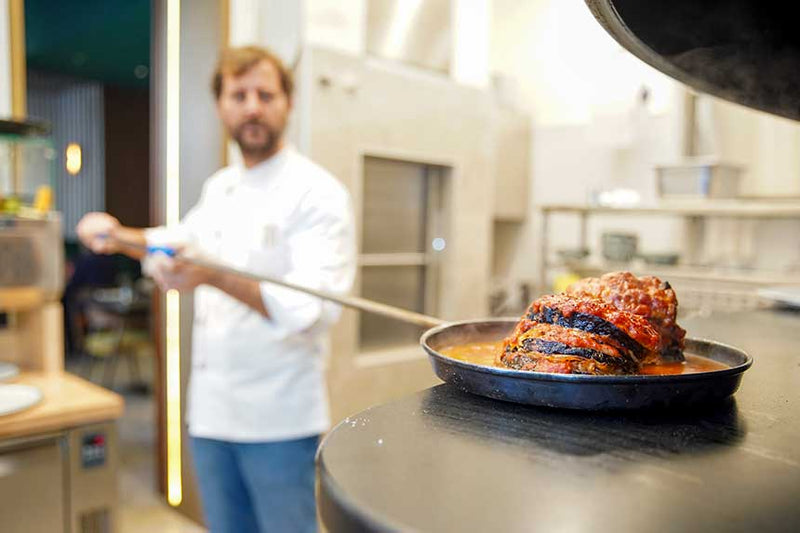 Chef di Modus serve una padella di carne in cucina
