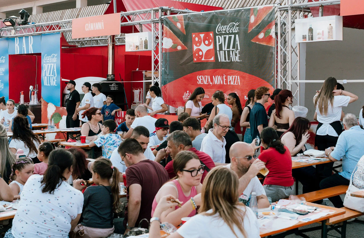 Folla seduta ai tavoli al Pizza Village di Napoli