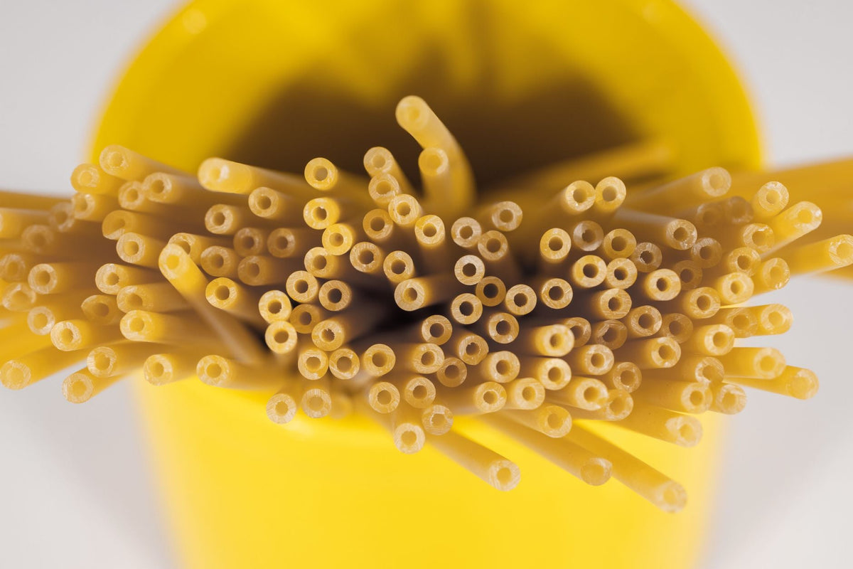 Spaghetti crudi in un contenitore giallo
